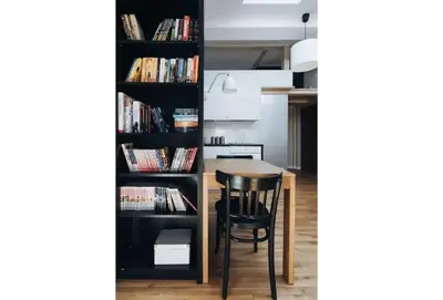 a room with a table and a book shelf with books at Apartment with mezzanine - Radziwiłłowska 27 in Kraków
