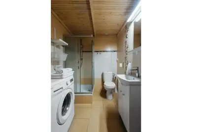 a bathroom with a washing machine and a toilet at Apartment with mezzanine - Radziwiłłowska 27 in Kraków