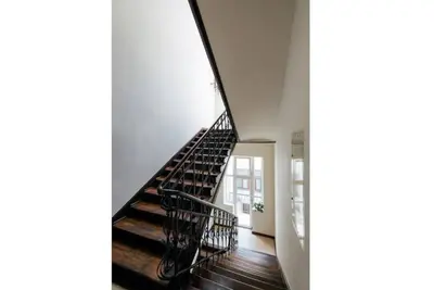 a spiral staircase in a building with white walls at Apartment with mezzanine - Radziwiłłowska 27 in Kraków