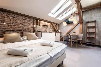 a bedroom with a large bed and a brick wall at Studio apartment with an AC - Dietla 51 street in Kraków