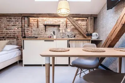 a kitchen with a table and chairs in a room at Studio apartment with an AC - Dietla 51 street in Kraków