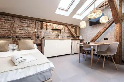 a bedroom with a bed and a table with chairs at Studio apartment with an AC - Dietla 51 street in Kraków