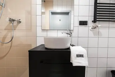 a bathroom with a sink and a shower at Studio apartment with an AC - Dietla 51 street in Kraków