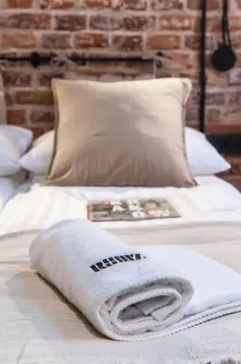 a white towel sitting on top of a bed at Studio apartment with an AC - Dietla 51 street in Kraków