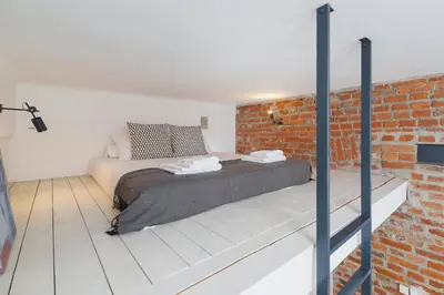 a bedroom with a bed and a brick wall at Kazimierz District - Miodowa 32 Street in Kraków