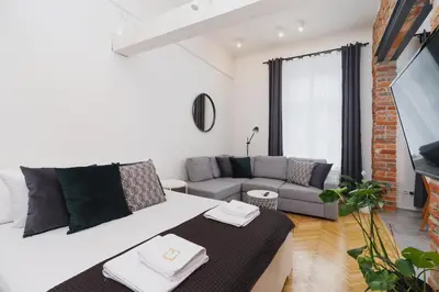 a living room with a couch and a tv at Kazimierz District - Miodowa 32 Street in Kraków