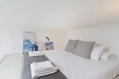 a white bedroom with a large white bed with pillows at Kazimierz District - Miodowa 32 Street in Kraków