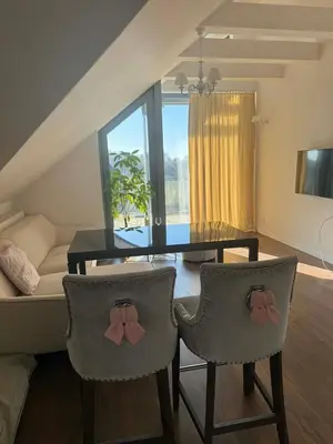 a kitchen with white cabinets and a black table and chairs at Nowy apartament na polu golfowym Paczółtowice in Paczółtowice