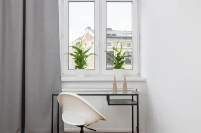 a desk and a chair in front of a window at 1-Bedroom Apartment with Balcony - Długa 65 in Kraków