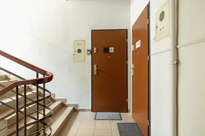 a hallway with a brown door and stairs at 1-Bedroom Apartment with Balcony - Długa 65 in Kraków