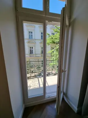 a door to a balcony with a view of a building at Apartamenty Inspiracja in Kraków