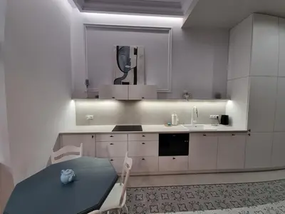 a white kitchen with a sink and a table at Apartamenty Inspiracja in Kraków
