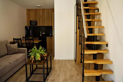 a living room with a staircase and a couch at Nadwiślańska Apartments - Lipowa, 11km od Zator, Energylandia in Zator