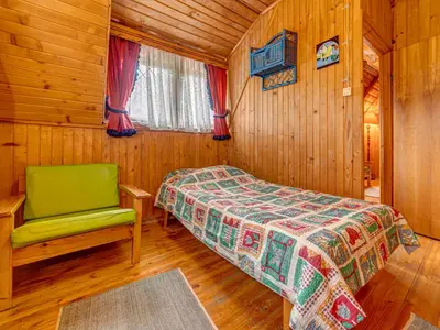 a bedroom with a bed and a chair in a cabin at Holiday Home Hatale by Interhome in Rzyki