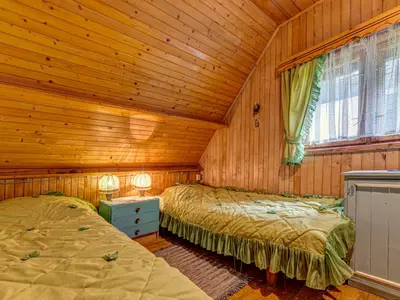 a bedroom with two beds in a log cabin at Holiday Home Hatale by Interhome in Rzyki