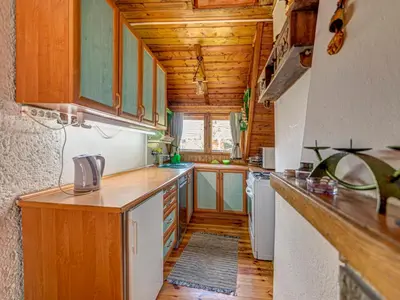a kitchen with wooden cabinets and a wooden floor at Holiday Home Hatale by Interhome in Rzyki