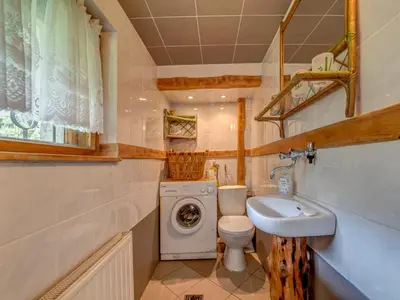 a bathroom with a toilet sink and a washing machine at Holiday Home Hatale by Interhome in Rzyki