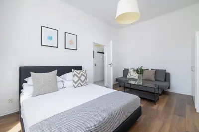a white bedroom with a bed and a couch at 2-Bedroom Apartment - Długa 65 in Kraków