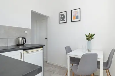 a kitchen with a white table and chairs at 2-Bedroom Apartment - Długa 65 in Kraków