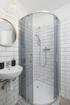 a white bathroom with a shower and a sink at 2-Bedroom Apartment - Długa 65 in Kraków