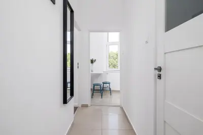 a hallway with white walls and a door and chairs at 1-Bedroom Apartment - Długa 65 in Kraków