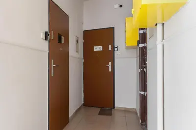 a hallway with two brown doors in a room at 1-Bedroom Apartment - Długa 65 in Kraków