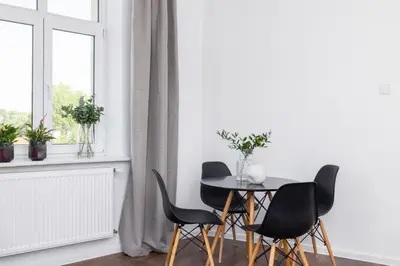 a table and chairs in a room with a window at 1-Bedroom Apartment - Długa 65 in Kraków