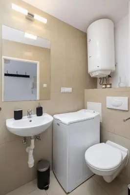 a white bathroom with a toilet and a sink at 1-Bedroom Apartment - Długa 65 in Kraków