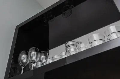 a black shelf with wine glasses on it at Apartment in the Old Town - Karmelicka Street in Kraków