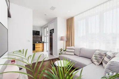 a living room with a couch and a large window at Apartment in the Old Town - Karmelicka Street in Kraków