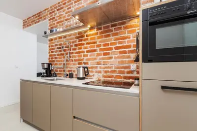 a kitchen with a brick wall and a sink at Karmelicka Street - Old Town in Kraków