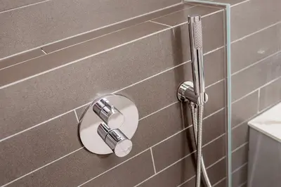 a shower with a hose attached to a tiled wall at Karmelicka Street - Old Town in Kraków