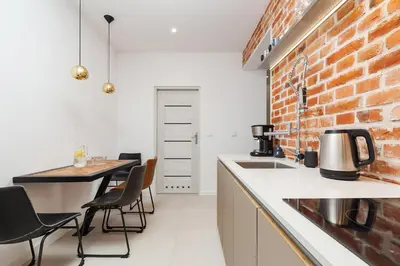 a kitchen with a counter and a brick wall at Karmelicka Street - Old Town in Kraków