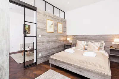 a bedroom with a large bed with a wooden wall at Karmelicka Street - Old Town in Kraków