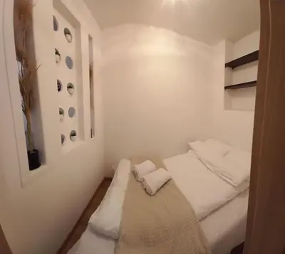 a small white room with a bed in it at Kawalerka w centrum in Wadowice