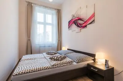 a bedroom with a bed with two pillows and a window at Centrum Apartments in Kraków