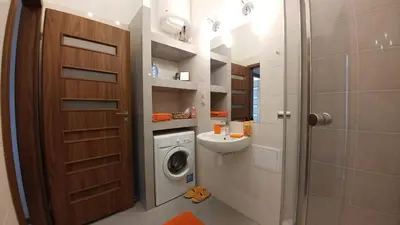 a bathroom with a washing machine and a sink at Centrum Apartments in Kraków
