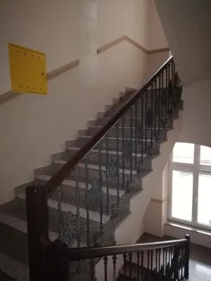 a staircase in a house with a yellow clock on the wall at Centrum Apartments in Kraków