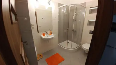 a bathroom with a shower and a sink and a toilet at Centrum Apartments in Kraków