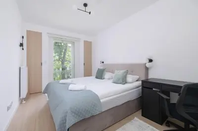 a bedroom with a bed with a desk and a computer at Krowoderska Apartment with Balcony near City Center by Rent like home in Kraków