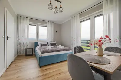 a bedroom with a bed and a table and chairs at Noclegi Sunny House in Witanowice