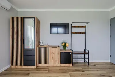 a room with a desk and a shelf with flowers at Noclegi Sunny House in Witanowice