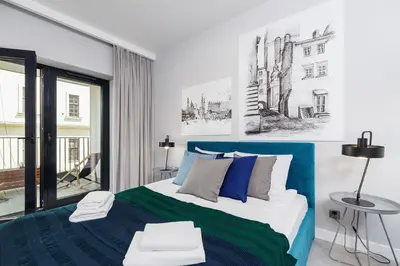 a bedroom with a blue and white bed and a window at Old Town Apartment with Balcony - Rajska 3 Street in Kraków