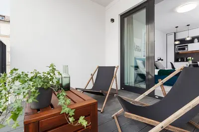 a living room with two chairs and a table at Old Town Apartment with Balcony - Rajska 3 Street in Kraków