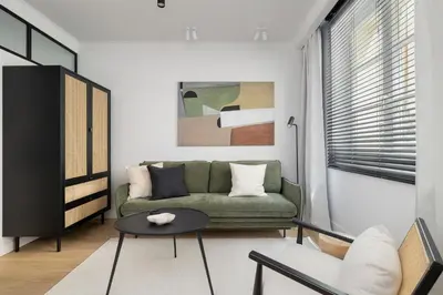 a living room with a green couch and a table at 1-Bedroom Apartment - Sławkowska 6a Street in Kraków