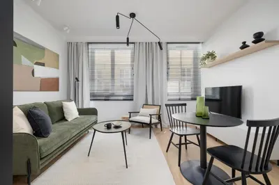 a living room with a green couch and a table at 1-Bedroom Apartment - Sławkowska 6a Street in Kraków