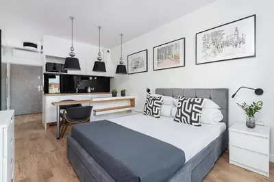 a bedroom with a bed and a desk in it at Cozy studio with a balcony - Rajska 3 street in Kraków