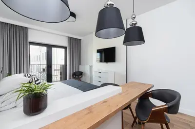 a bedroom with a bed and a table and chairs at Cozy studio with a balcony - Rajska 3 street in Kraków