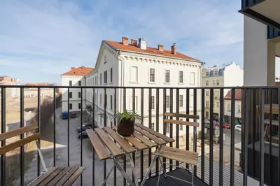 a balcony with a wooden table and a plant on it at Cozy studio with a balcony - Rajska 3 street in Kraków