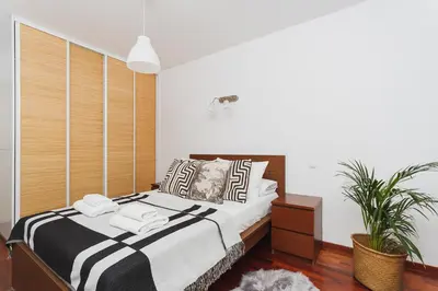 a bedroom with a bed with black and white pillows at 3-Bedroom Apartment with balcony- Krowoderska in Kraków